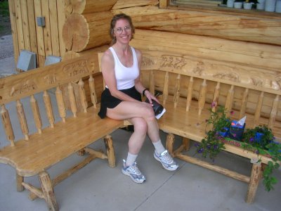 Terry poses on bench with hand carved figures.